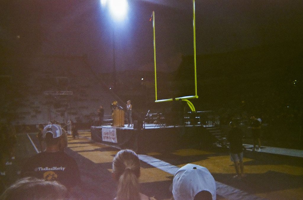 Herky and host standing on a stage at Kinnick Stadium.